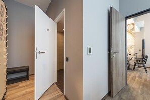 A modern interior with a wooden bench, a white door, and a dining area with chairs and a table. - Harbr. Hotel Heilbronn (Heilbronn)