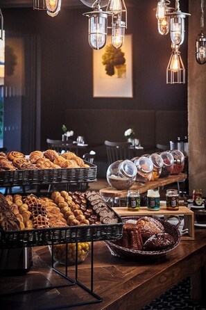 A buffet with various baked goods and jars of condiments. - Hotel Louvre Lens (Lens)