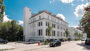 A white building with multiple windows and a red fire hydrant on the sidewalk. - Centerroom Landshut City (Landshut)