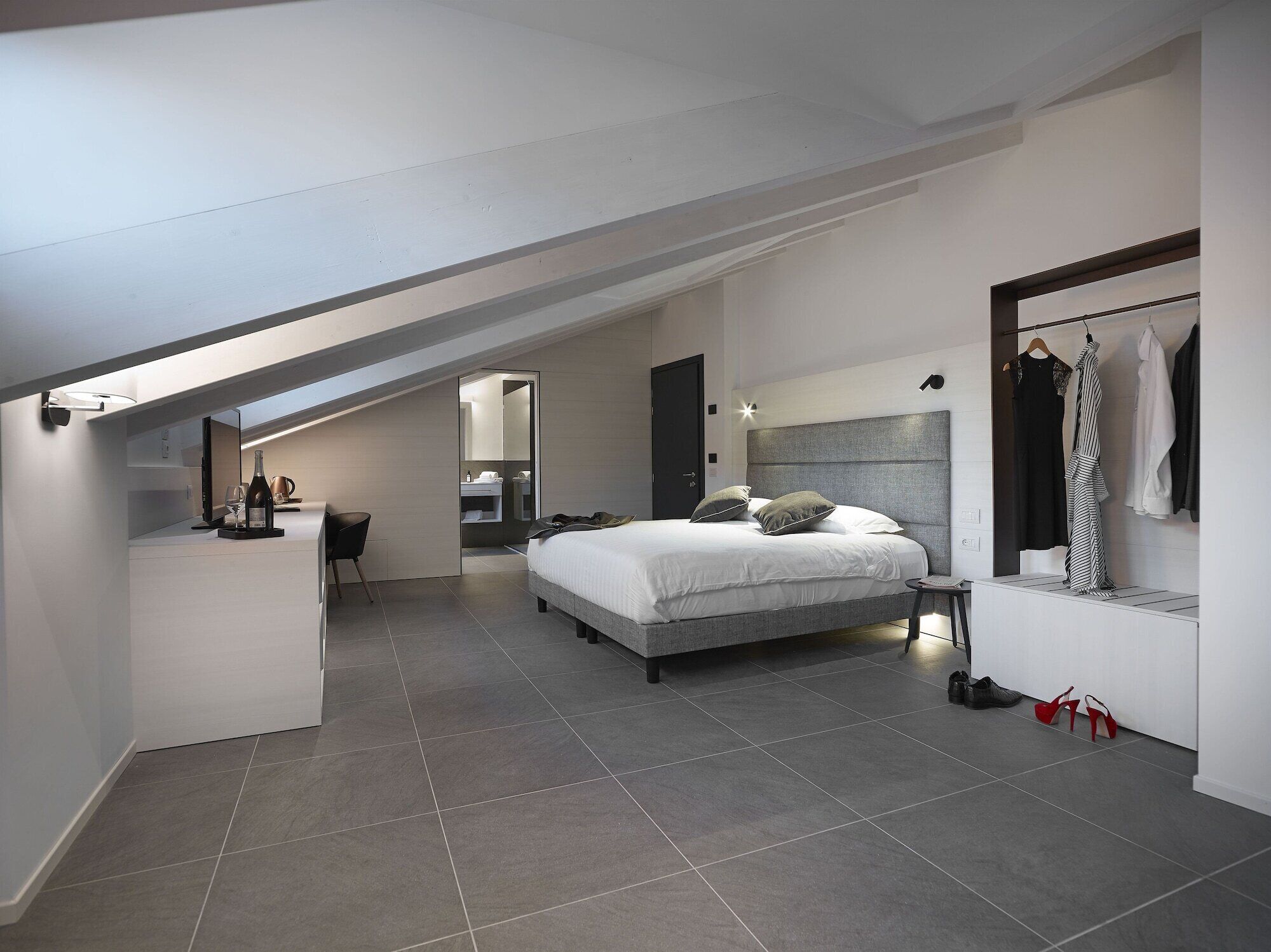 Camera moderna con un letto grande, una scrivania e un cabina armadio.