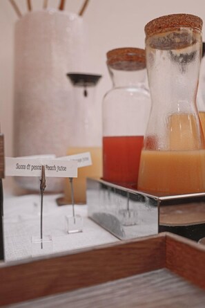 A display of beverages with a sign indicating 'Succo di pesca Peach juice'. - Boutique Hotel Touring (Verona)