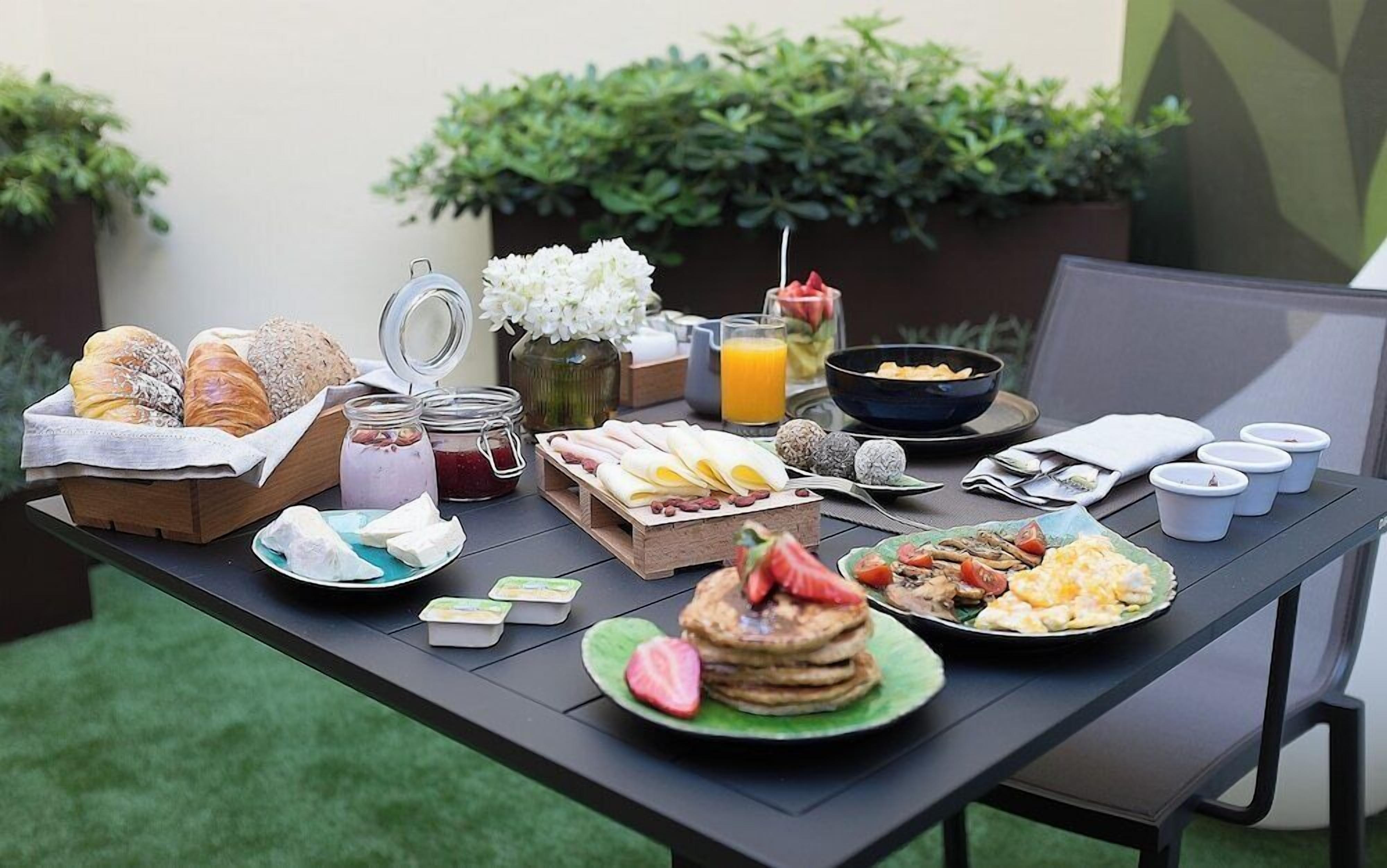 A breakfast table with pastries, fruits, and beverages.