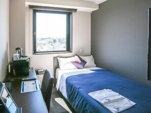 A hotel room with a bed, a desk with a computer, a coffee maker, and a window with a city view. - Hotel Livemax Takadanobaba Ekimae (Tokyo)