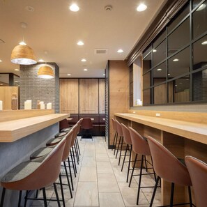Eine moderne Bar mit Holztresen und Barhocker.
