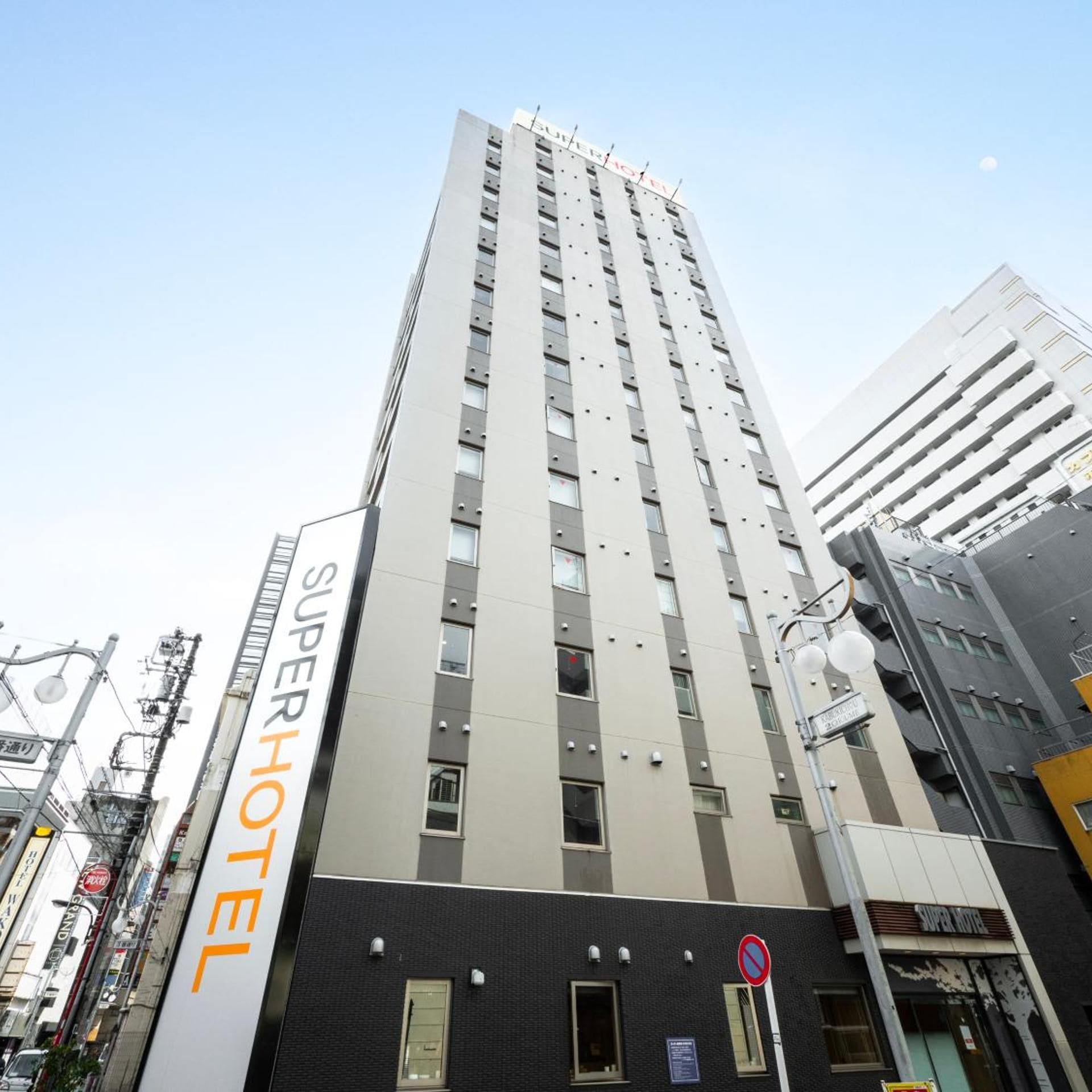 A tall hotel building with multiple floors and a sign reading 'SUPERHOTEL'.