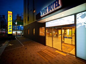 Ein schönes Hotel mit moderner Fassade, großem Glaseingang und gut sichtbarer Schilderung.