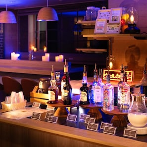 Eine Bar mit verschiedenen Spirituosenflaschen und einem Kerzenarrangement.