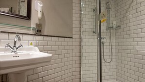 A bathroom with a white sink, a glass shower enclosure, and a mirror. - Cedars Lodge Inn (Barnstaple)