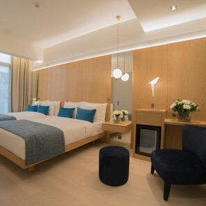A modern bedroom with a large bed, bedside tables, a desk, a chair, and a fireplace. - Galata's Hotel Istanbul (Istanbul)