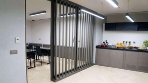 A modern office space with a partitioned area, a kitchenette, and a dining area with chairs and tables. - Galata's Hotel Istanbul (Istanbul)