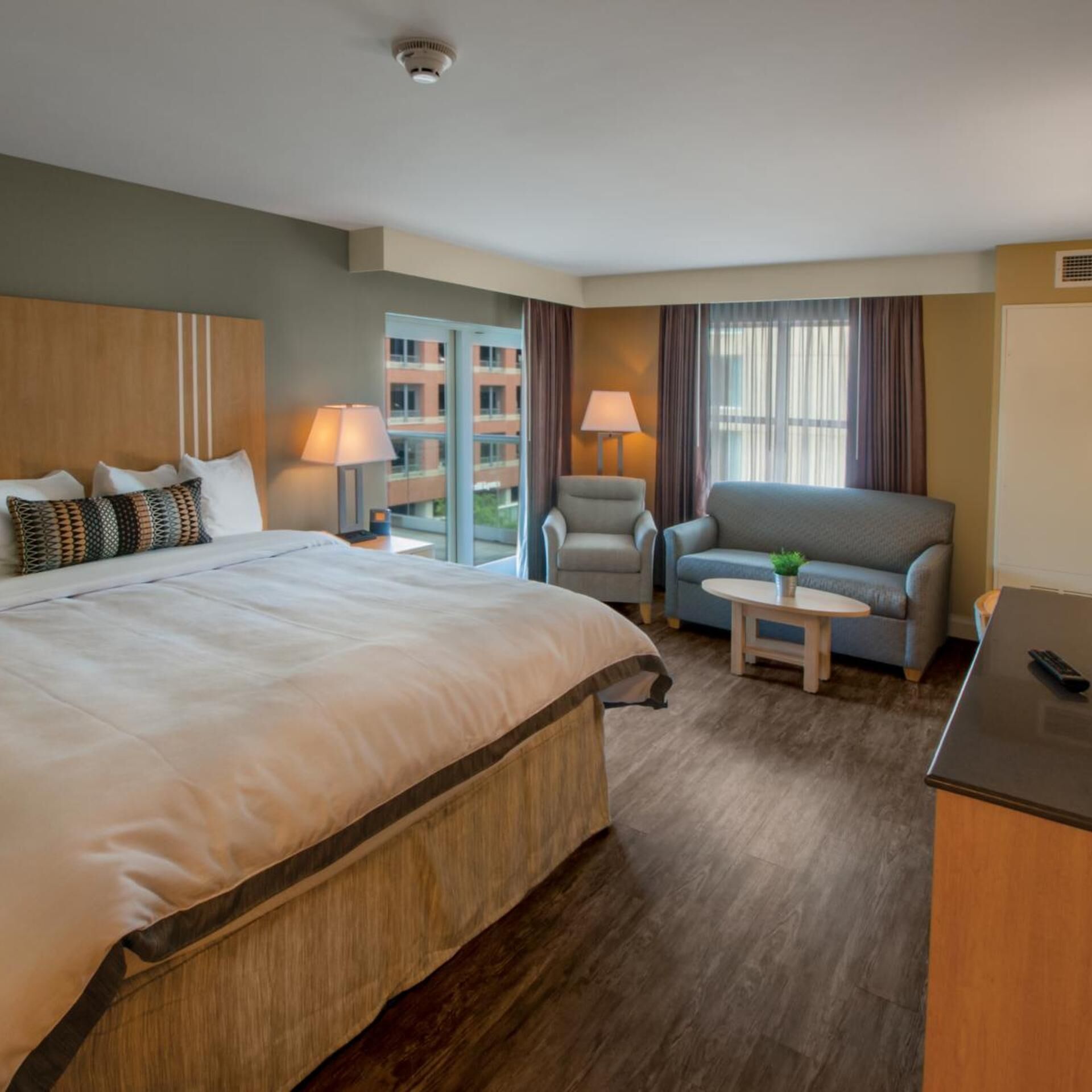 Ein Hotelzimmer mit einem großen Bett, einem Schlafsofa, einem kleinen Tisch und einem Schreibtisch.