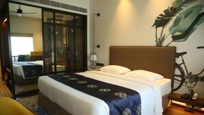 Une chambre d’hôtel avec un grand lit, un vélo et un miroir.