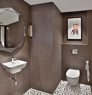 Een moderne badkamer met een grote spiegel, een wastafel, toilet en douche.