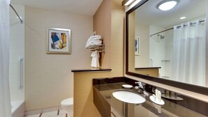 Et moderne badeværelse med et stort spejl, en håndvask, et toilet og en brusekabine.