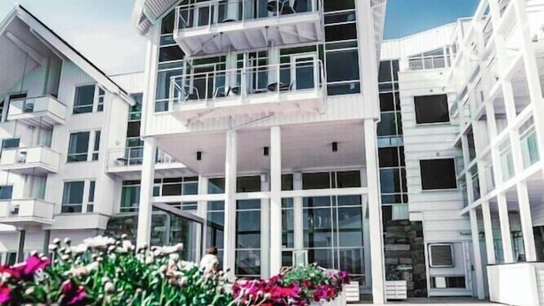 A modern building with a curved roof and multiple balconies. - Hotell Molde Fjordstuer (Molde)