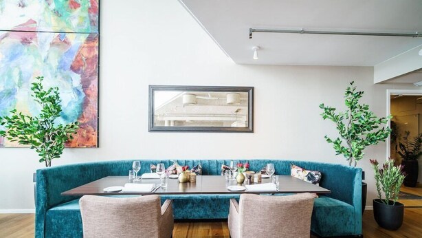 A modern dining area with a teal upholstered bench, a rectangular table, and two chairs. - Hotell Molde Fjordstuer (Molde)