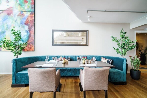 Ein moderner Essbereich mit einer beruhigend blauen gepolsterten Bank, einem rechteckigen Tisch und zwei Stühlen.