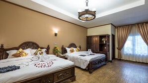 A hotel room with two wooden beds, a chandelier, a nightstand, and a wardrobe. - Bali Hotel (Phnom Penh)