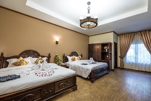 A hotel room with two wooden beds, a chandelier, a nightstand, and a wardrobe. - Bali Hotel (Phnom Penh)