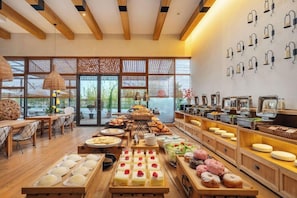 Un buffet proposant une variété de plats et un espace où l’on peut s’asseoir, avec des chaises et des tables.