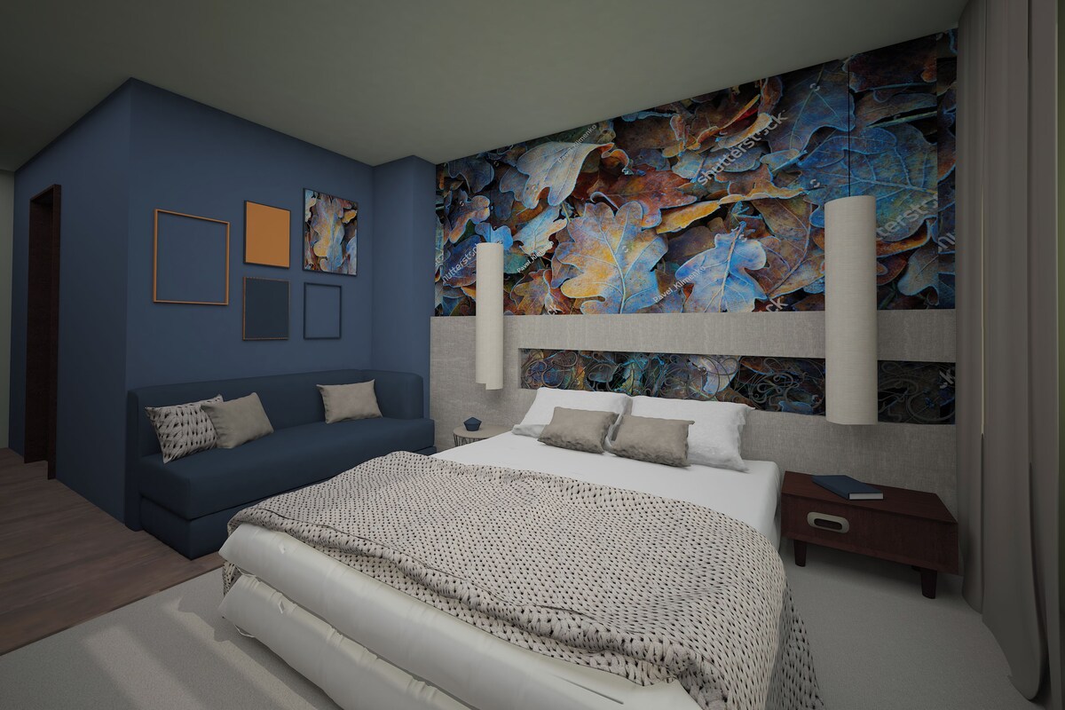 A modern bedroom with a large bed, a blue sofa, and a colorful abstract painting on the wall.
