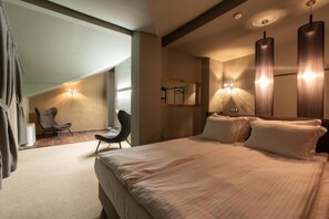 A modern hotel room with a large bed, a chair, and a mirror. - Ores Boutique Hotel (Bansko)