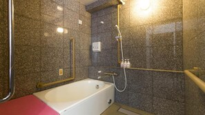 A modern bathroom with a bathtub, shower, and handrails. - Toyoko Inn Urawa Misono eki Higashi Guchi (Saitama)