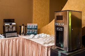 Uma estação de café com máquina de café, chávenas e uma variedade de cápsulas de café.
