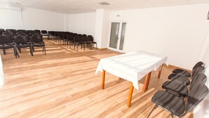 A conference room with a white table and chairs arranged for a meeting. - Hotel Mures (Sânmartin)