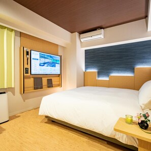A hotel room with a bed, a desk with a computer, an air conditioner, and a wall-mounted TV. - Daiwa Royal Hotel D City Nagoya Fushimi (Nagoya)