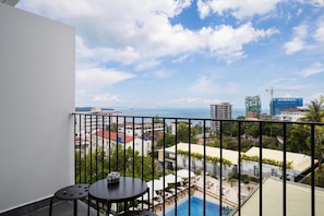 Ein Balkon mit Blick auf einen Pool, einem Tisch und Stühlen.