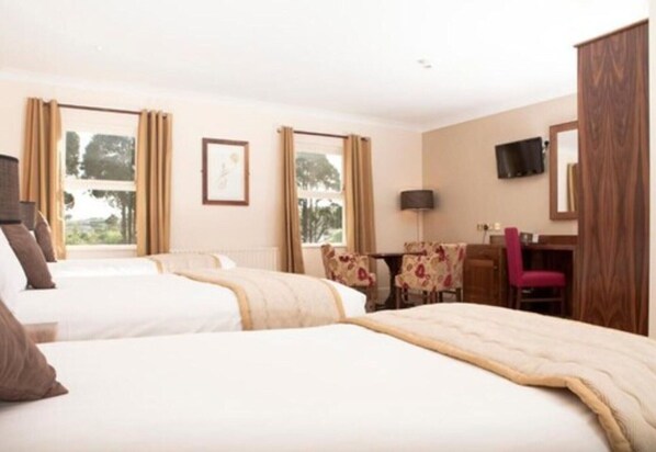 A hotel room with two beds, a desk, a chair, and a TV. - Lakeside Hotel And Leisure Centre (Ballina)