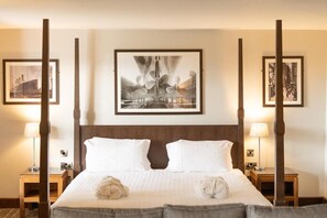 A hotel room with a large bed, two bedside tables, a headboard, and framed artwork on the walls. - Redcastle Hotel (Moville)