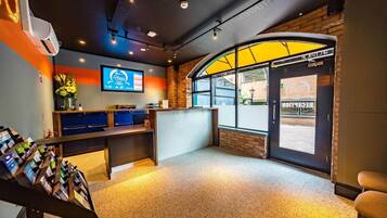 A reception area with a counter, a TV screen, and a door marked 'RECEPTION'.