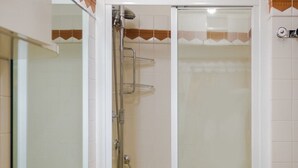 A bathroom with a white sink, mirror, and shower enclosure. - Residence Tynska (Prague)