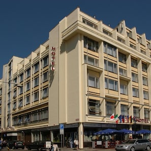 A multi-story hotel with a prominent 'HOTEL' sign, a ground-level restaurant, and a parking sign. - Hotel Central (Plzen)