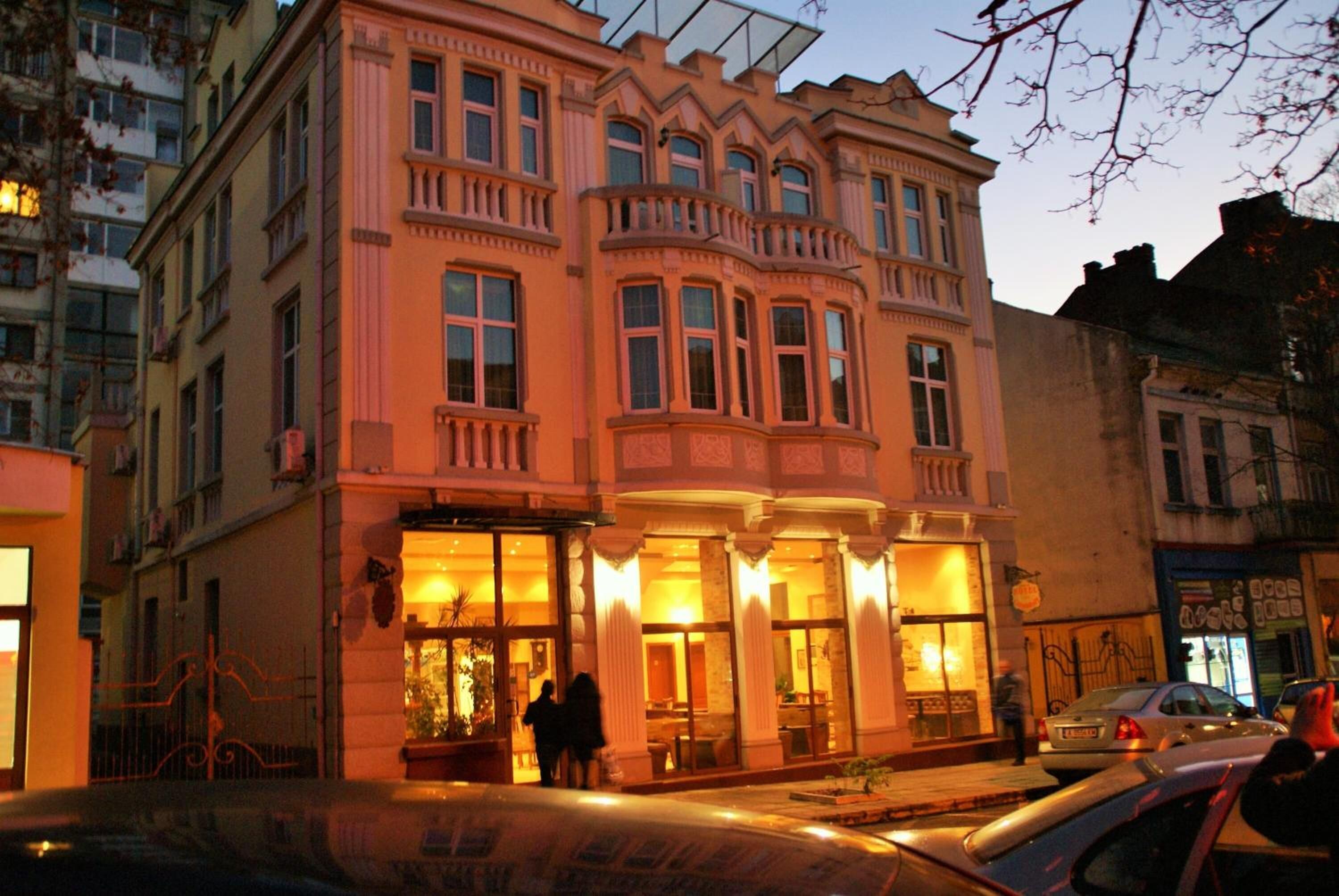 A historic building with large windows and a balcony, likely a hotel or public building.