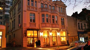 Un edificio histórico con ventanas amplias y un balcón, presumiblemente un hotel o edificio público.