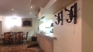 A dining area with a brick wall, a counter with kitchen items, and a seating arrangement with chairs and a table. - Chipilakoff (Burgas)