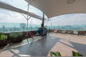 A rooftop terrace with wooden flooring, potted plants, and seating areas. - The Green Escape Suite (Mexico City)
