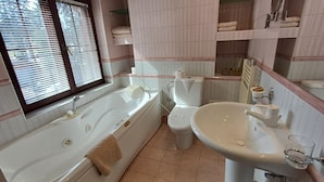 A bathroom with a bathtub, toilet, and sink. - Alpin (Samokov)