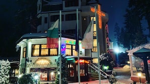 A multi-story building with a restaurant on the ground floor, a ski lift, and a sign indicating a ski resort. - Alpin (Samokov)