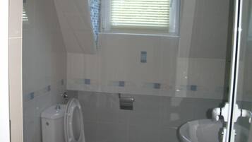 A bathroom with a toilet, bidet, and sink.