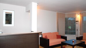 Un salon moderne avec un canapé, une table basse et un petit coin bar.