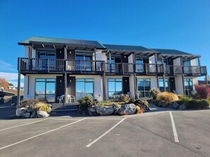 A two-story building with a balcony on the ground floor and a flat roof. - Lake Tekapo Scenic Resort (Lake Tekapo)