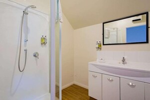A bathroom with a shower, a sink, and a mirror.
