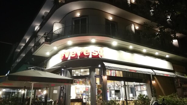 A multi-story building with a prominent 'Everest' sign on the ground floor, indicating a hotel or restaurant. - Miramare (Naousa)