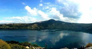 A panoramic view of a lake surrounded by hills and mountains. - Castel Gandolfo (Castel Gandolfo)