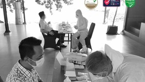 A vaccination center with a table, chairs, and a person administering a vaccine. - Mambruk Anyer (Anyer)