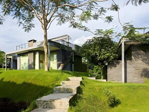 A modern house with a staircase leading to a wooden deck. - Tea Garden Resort (Sagalaherang)